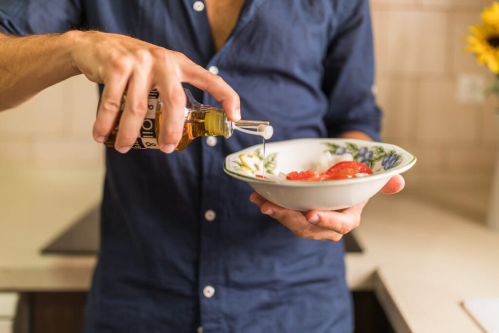 uomo che versa olio in una ciotola